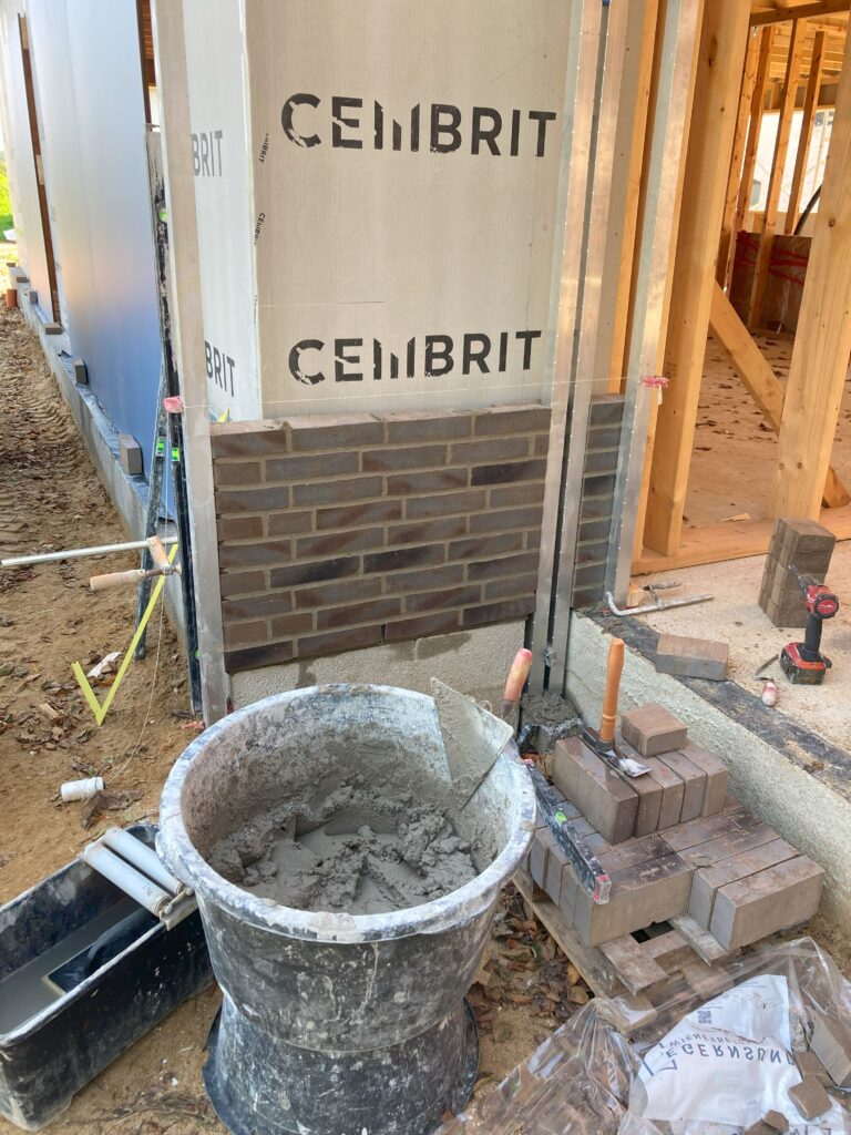 Byggeplads med mursten og mørtelspand ved renovering