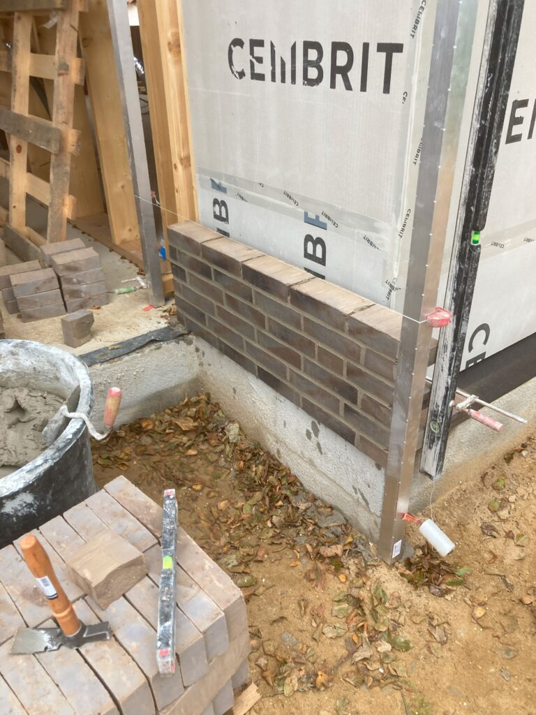 Murværk under konstruktion ved byggeri, tæt på beton.