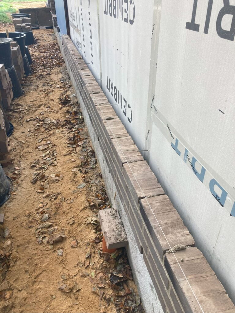 Mur under konstruktion med isolering og blade.