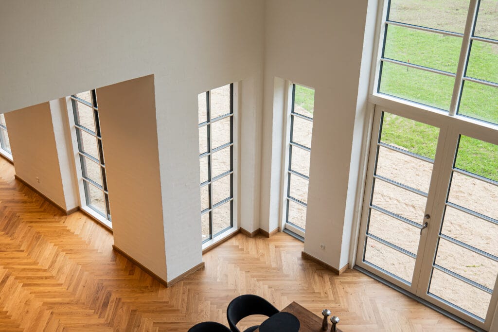 Store vinduer i moderne stue med trægulv